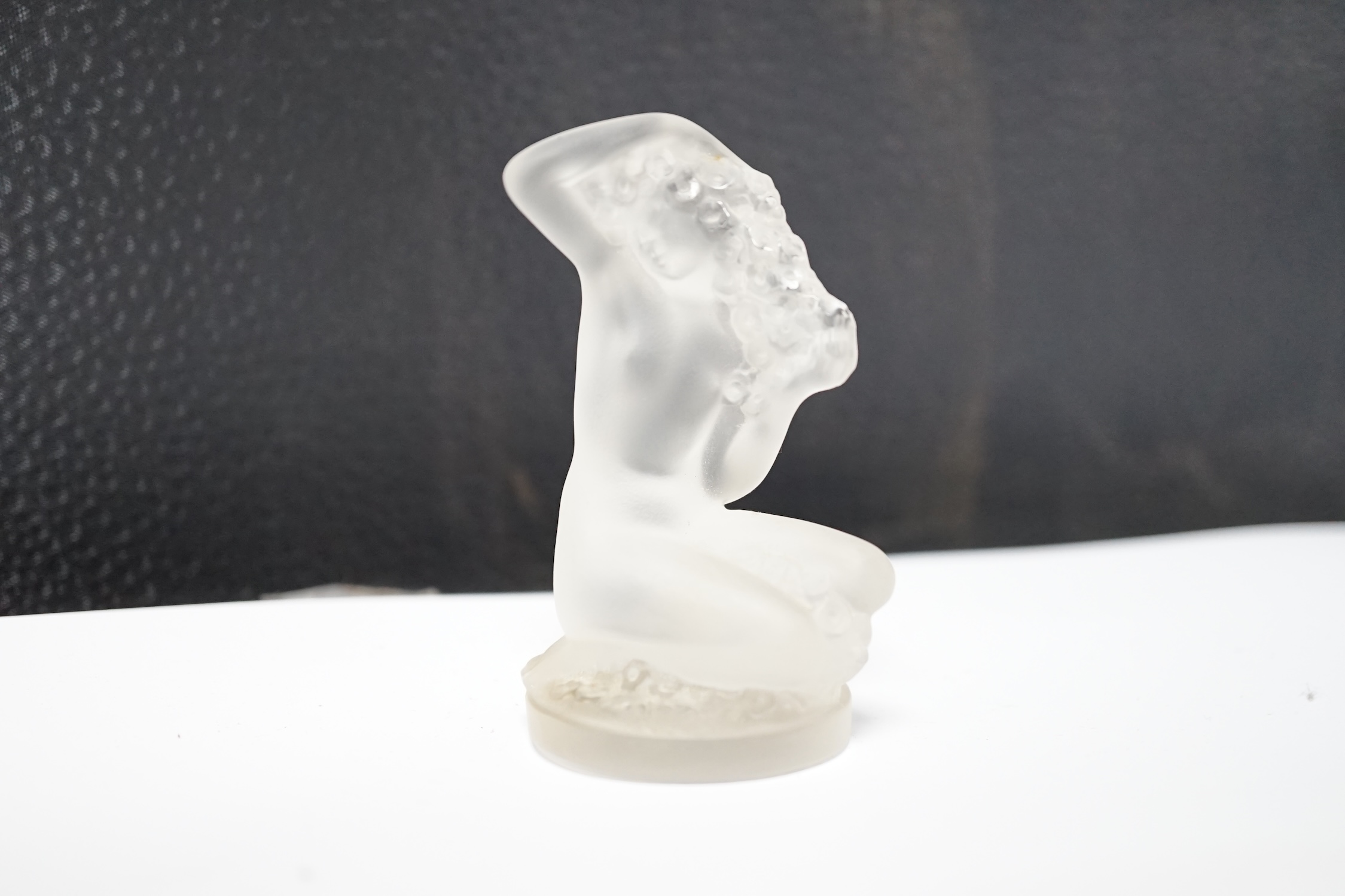 A Lalique glass figure of a kneeling female, signed, 8cm high